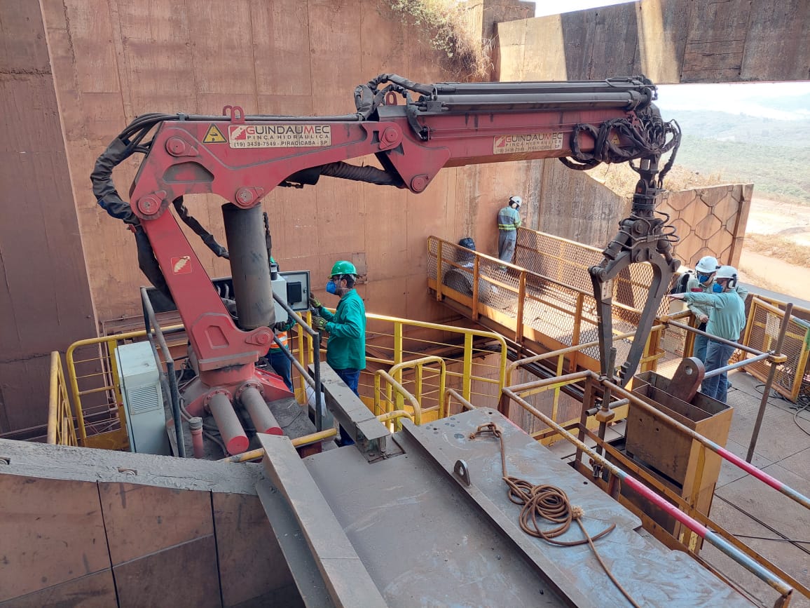 Imagem de um pinça hidráulica de grande porte operando em uma construção civil, elevando materiais pesados com segurança e eficiência, durante o dia. Vale Brucutu